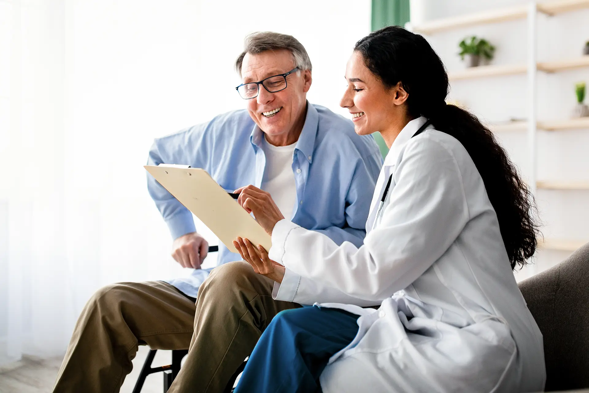woman doctor talking to an older male patient