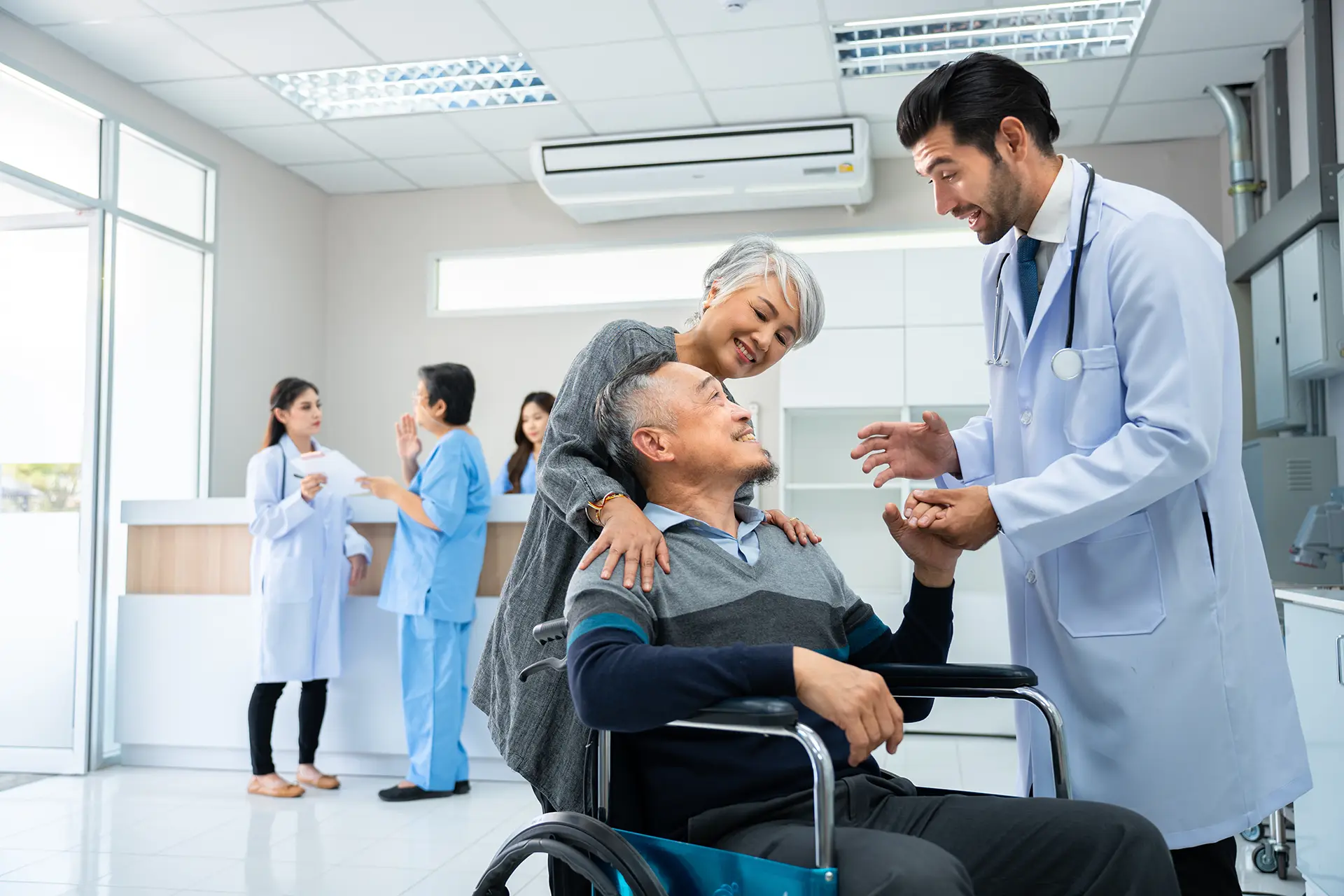 older patient in a wheel chair talking to a doctor