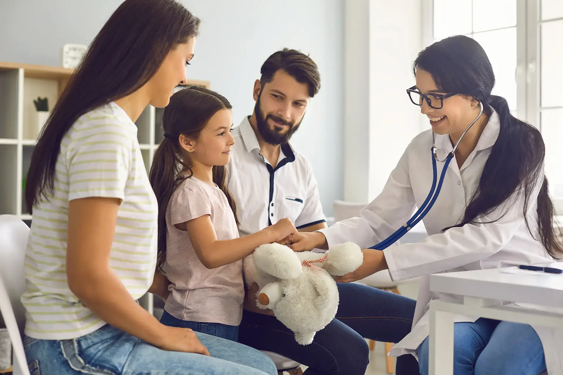 woman doctor with parents and girl at a checkup