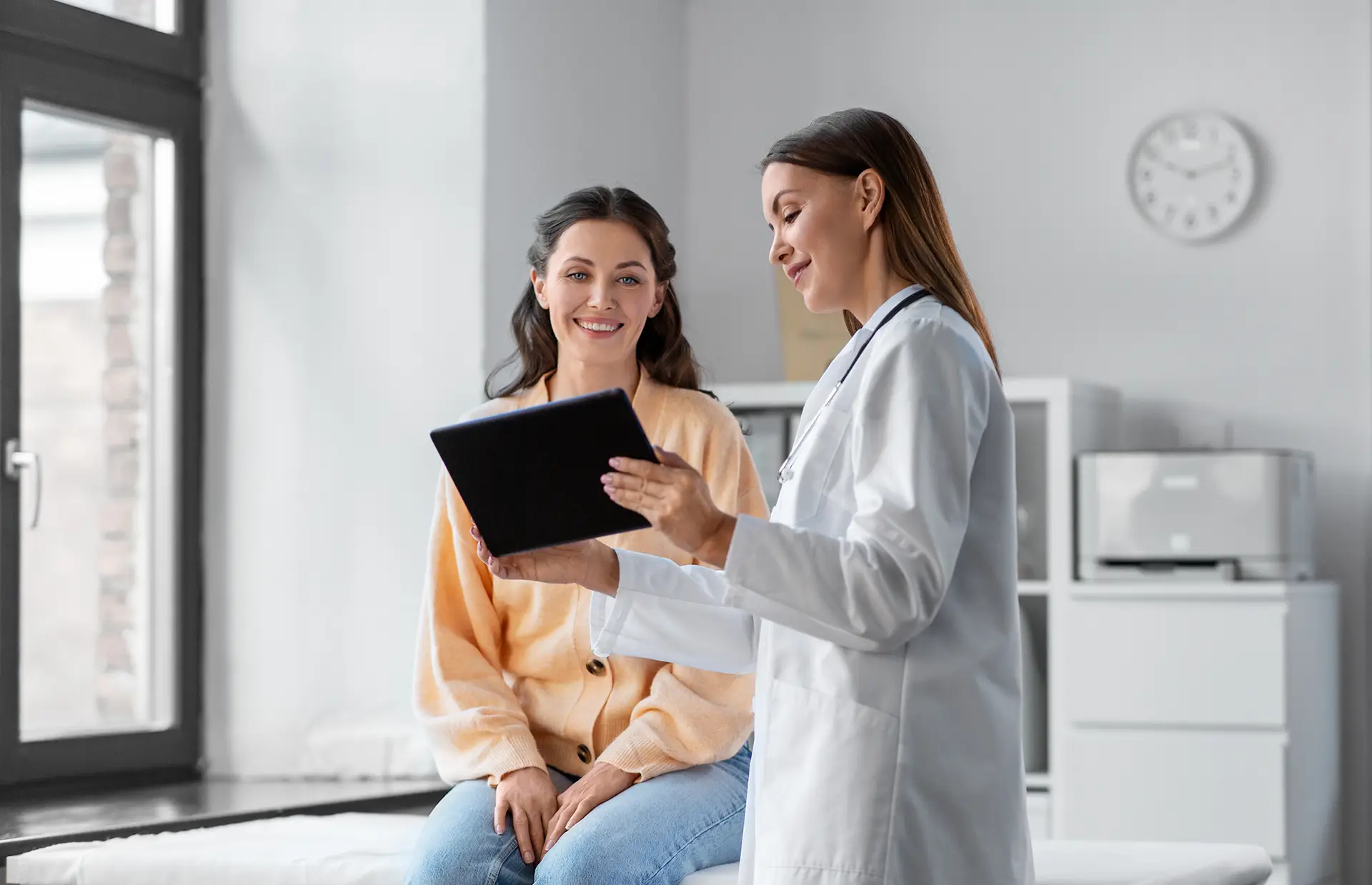 woman doctor with a female patient looking at an ipad